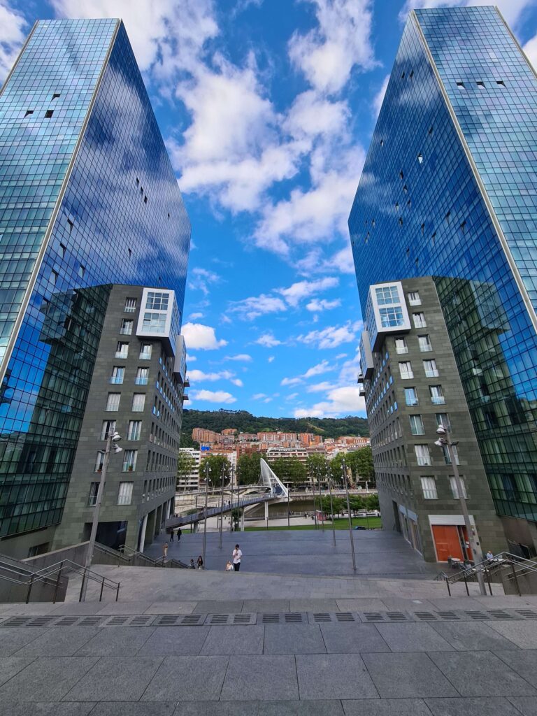 La gran escalinata de las Torres Isozaki en Bilbao, con el puente Zubizuri al fondo